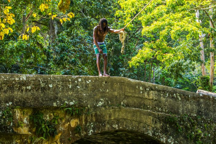 Man Standing on a Concrete Bridge Holding a Rope